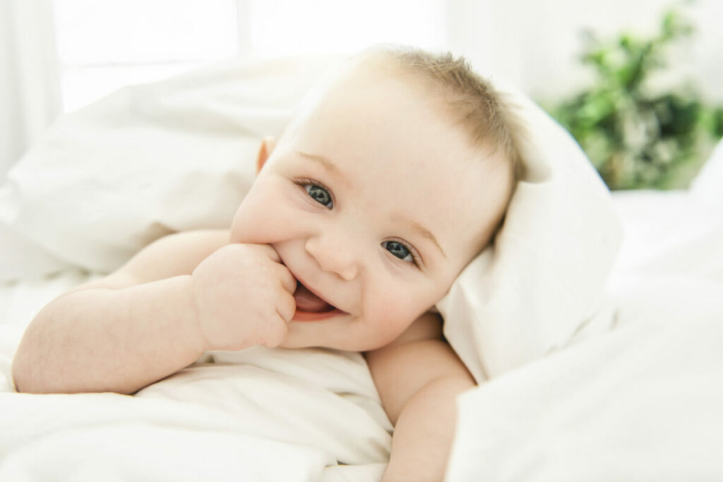 Babyfotografie: Baby lacht in Kamera